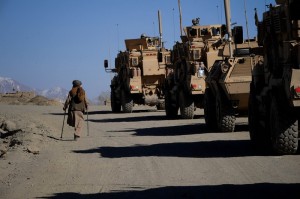 Un uomo afgano, disabile, cammina accanto a un convoglio militare, Afghanistan. Credits: OxfamGB