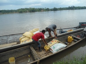 La consegna del mangime per polli, portato lungo il fiume in canoa