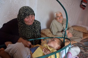 Um Mustaffa con il nipotino Mohammed nella tenda dove vive con la famiglia. Credits: Oxfam