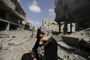 Gaza, una donna tra le macerie della propria casa