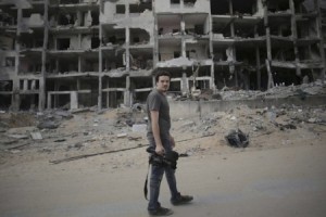 Associated Press video journalist Simone Camilli walks against a backdrop of destroyed buildings in Beit Lahiya in the Gaza Strip Associated Press video journalist Simone Camilli walks against a backdrop of destroyed buildings in Beit Lahiya in the Gaza Strip