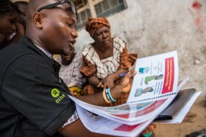 Abdul Razak Baimba spiega le misure di prevenzione a Congo Town. Credits: Tommy Trenchard/Oxfam