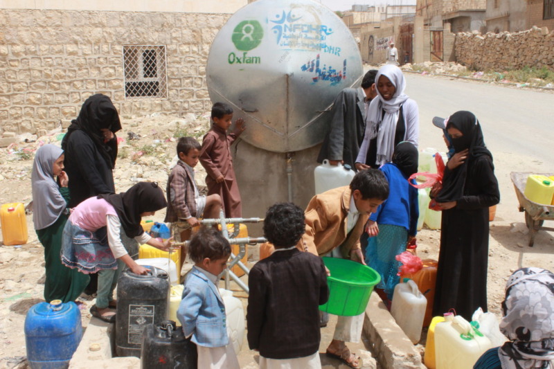 persone che vanno a raccogliere l'acqua da un distributore Oxfam