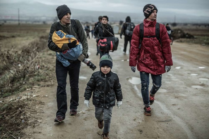 Un gruppo di rifugiati sfida la pioggia e il gelo per attraversare la frontiera della Macedonia con la Serbia