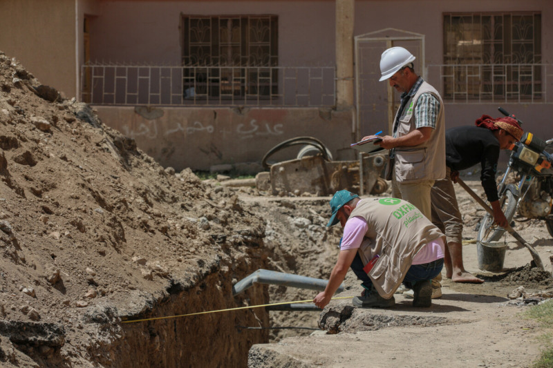 Ingegneri sanitari di Oxfam ispezionano i lavori di riabilitazione dei sistemi fognari e idrici nella zona rurale di Deir Ez-Zor, nel 2022.
