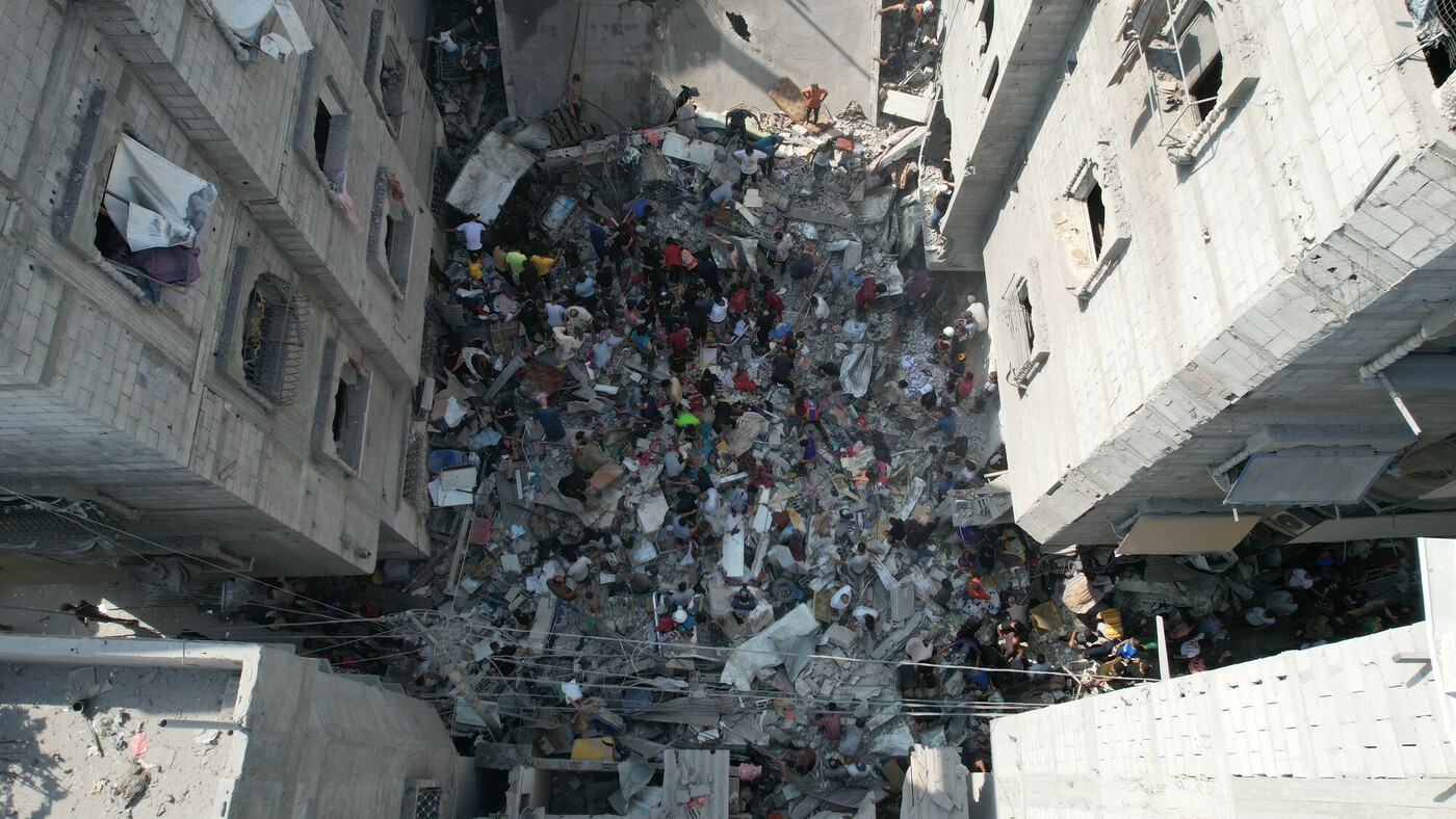 Ricerca di persone disperse sotto le rovine di uno degli edifici residenziali bombardati a Al Zahra City.