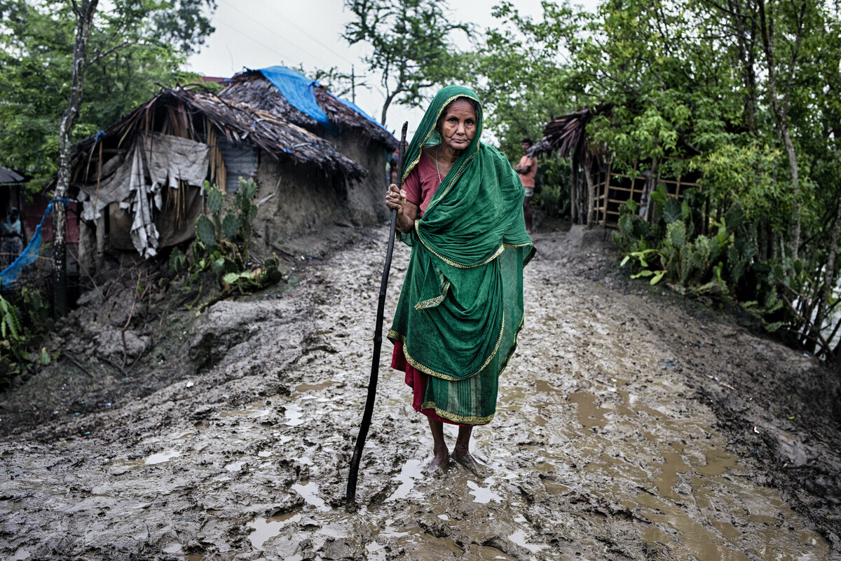 Una donna cammina tra le rovine del suo villaggio in Bangladesh, distrutto dopo il passaggio del ciclone Amphan.