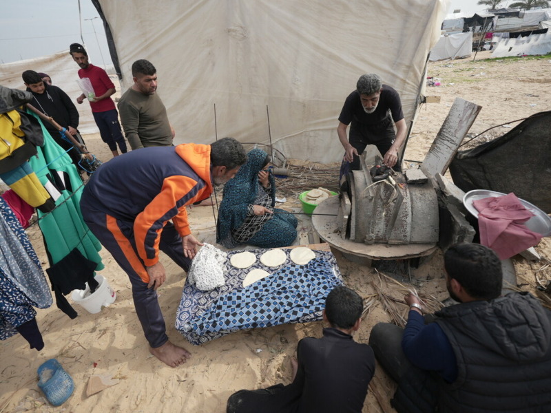 Muna insieme al marito Mutaz* e ad alcuni membri della famiglia raccolti intorno al forno di argilla che hanno costruito. Foto: Alef Multimedia/ Oxfam