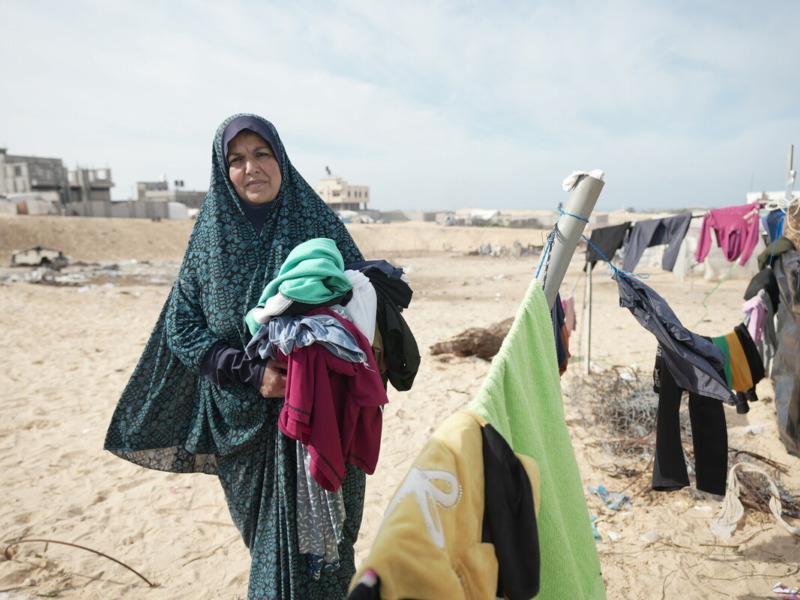 Muna* mentre fa il bucato accanto alla sua tenda ad Al Mawasi