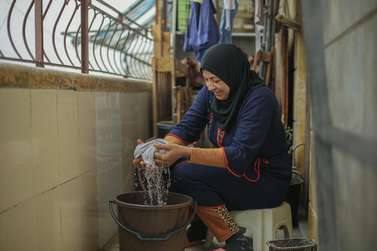 Khadija fa il bucato in un secchio poiché la sua zona ha perso l'elettricità a seguito del terremoto che ha colpito la Siria a febbraio. Foto: Islam Mardini/ Oxfam.