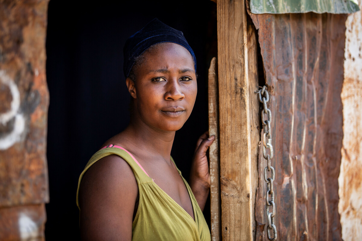 Progetto PAM, Sud Africa, De Doorns, 13.05.2021, Primrose Mulenga, 25 anni, posa per un ritratto sulla porta della casa di una stanza che condivide con il marito e i due figli nell'insediamento informale di De Doorns. Originaria dello Zimbabwe, Primrose è arrivata in Sud Africa in cerca di lavoro. La piccola città di De Doorns è il più grande esportatore di uva da tavola del Sud Africa e la maggior parte della popolazione è composta da braccianti agricoli stagionali. Grandi profitti da un lato, salari estremamente bassi dall’altro: la disuguaglianza lungo le filiere del nostro sistema alimentare è enorme. Mentre i supermercati tedeschi realizzano profitti, i lavoratori delle piantagioni che raccolgono il cibo che compriamo nei supermercati tedeschi lavorano per salari troppo bassi anche solo per comprare cibo a sufficienza per se stessi. L'organizzazione partner sudafricana di Oxfam, Women on Farms Project (WoFP), sostiene i lavoratori agricoli - in particolare le donne che lavorano nelle aziende vinicole sudafricane - e lotta insieme a loro per i diritti delle donne, condizioni di lavoro dignitose e contro la discriminazione e lo sfruttamento. Un obiettivo importante è quello di informare le donne sui loro diritti e di sostenerle nell’organizzazione delle proteste, nonché sui cambiamenti a livello politico. Oxfam li sostiene con la campagna europea "Il nostro cibo, il nostro futuro"