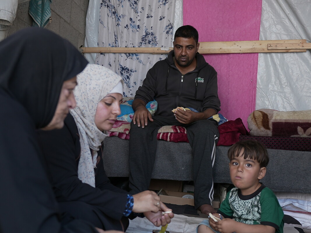 Ibrahim con la moglie, il figlio più piccolo e la madre mentre mangiano nella loro tenda. Foto: Alef Multimedia/Oxfam 