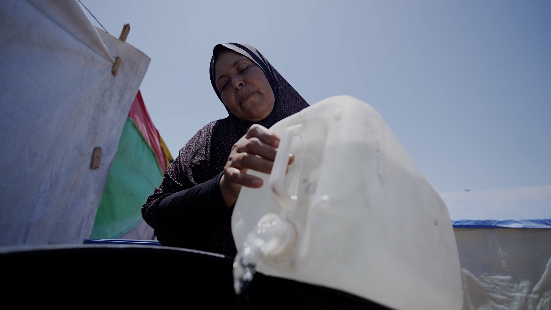 Feryal attinge l’acqua pulita nei pressi della sua tenda Foto: Oxfam