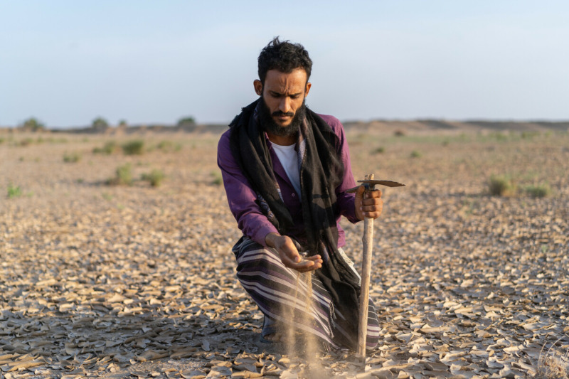 Bakeel Jahes, 27 anni, mentre tiene in mano la sabbia del terreno desertificato. La famiglia di Jahes ha perso quasi il 60% della propria terra nella città di Al-Wahat, governatorato di Lahj, a causa della desertificazione, delle inondazioni e della guerra. Credit: Gabreez / Oxfam