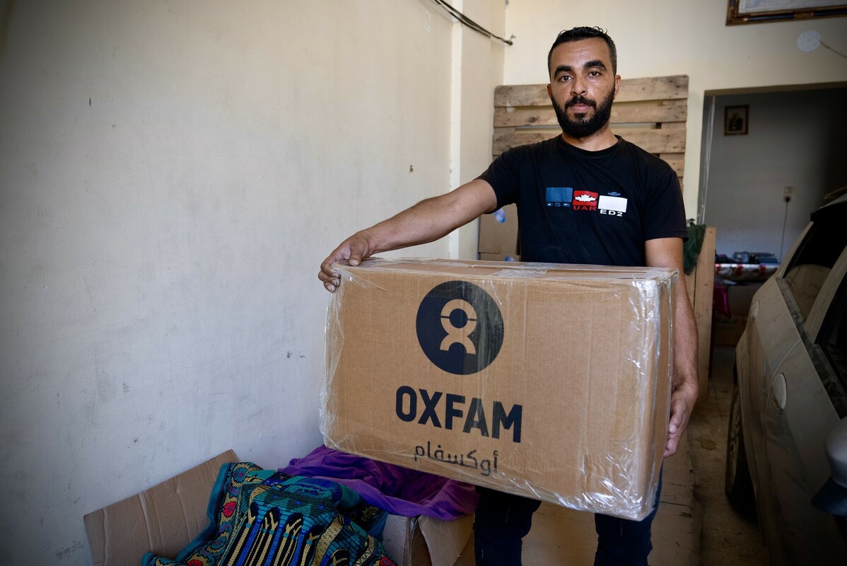 Raed Mansour tiene in mano il pacco alimentare Oxfam distribuito tra gli sfollati. Lui e sua moglie sono preparerenno cibo per i loro tre figli che hanno perso molto peso durante la guerra di Israele a Gaza. Credit: Alef Multimedia Company/ Oxfam