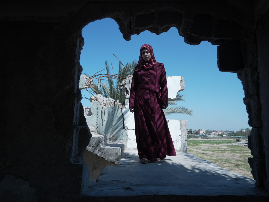 Suhad, madre palestinese, guarda la camera in un momento di quiete durante il conflitto a Gaza, mentre affronta una gravidanza ad alto rischio in condizioni estreme.