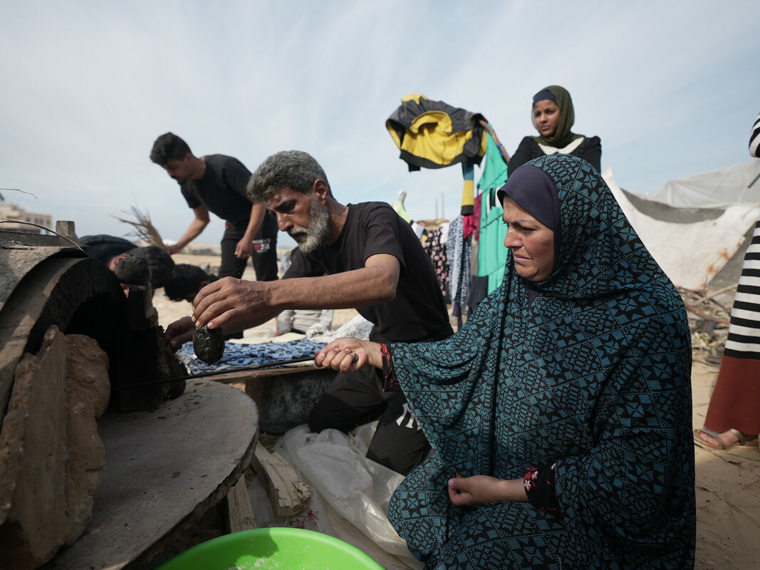 Famiglia palestinese sfollata da Khan Younis cucina del pane in un forno costruito da loro in un insediamento informale. Credit: Alef Multimedia/ Oxfam 