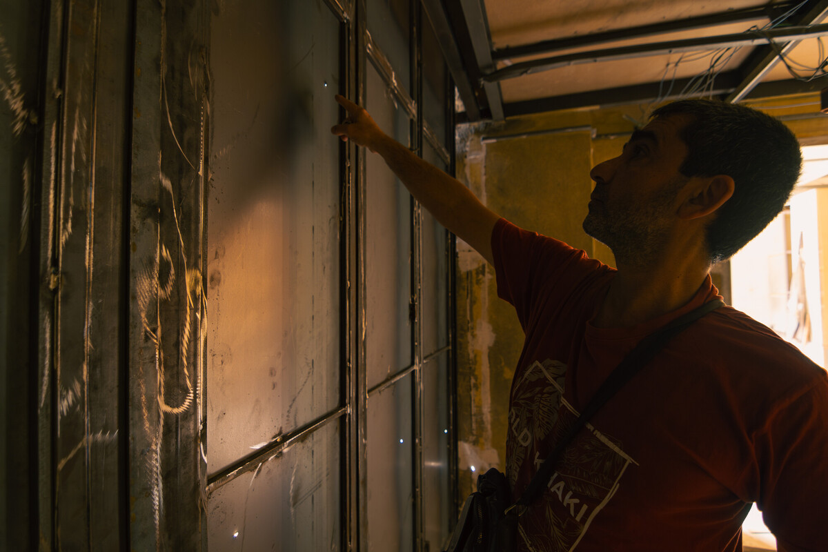 Ali Sheikh, un residente, mostra i segni della devastazione nel suo negozio distrutto nel Libano meridionale. Credit: Christian Harb/Oxfam