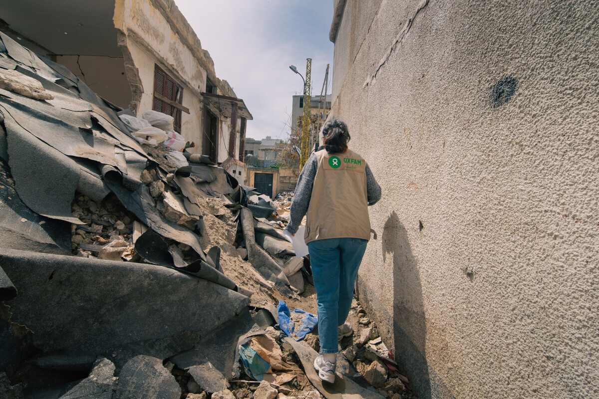 Una operatrice di Oxfam cammina tra le macerie e le strutture crollate nel sud del Libano. Credit: Christian Harb/Oxfam