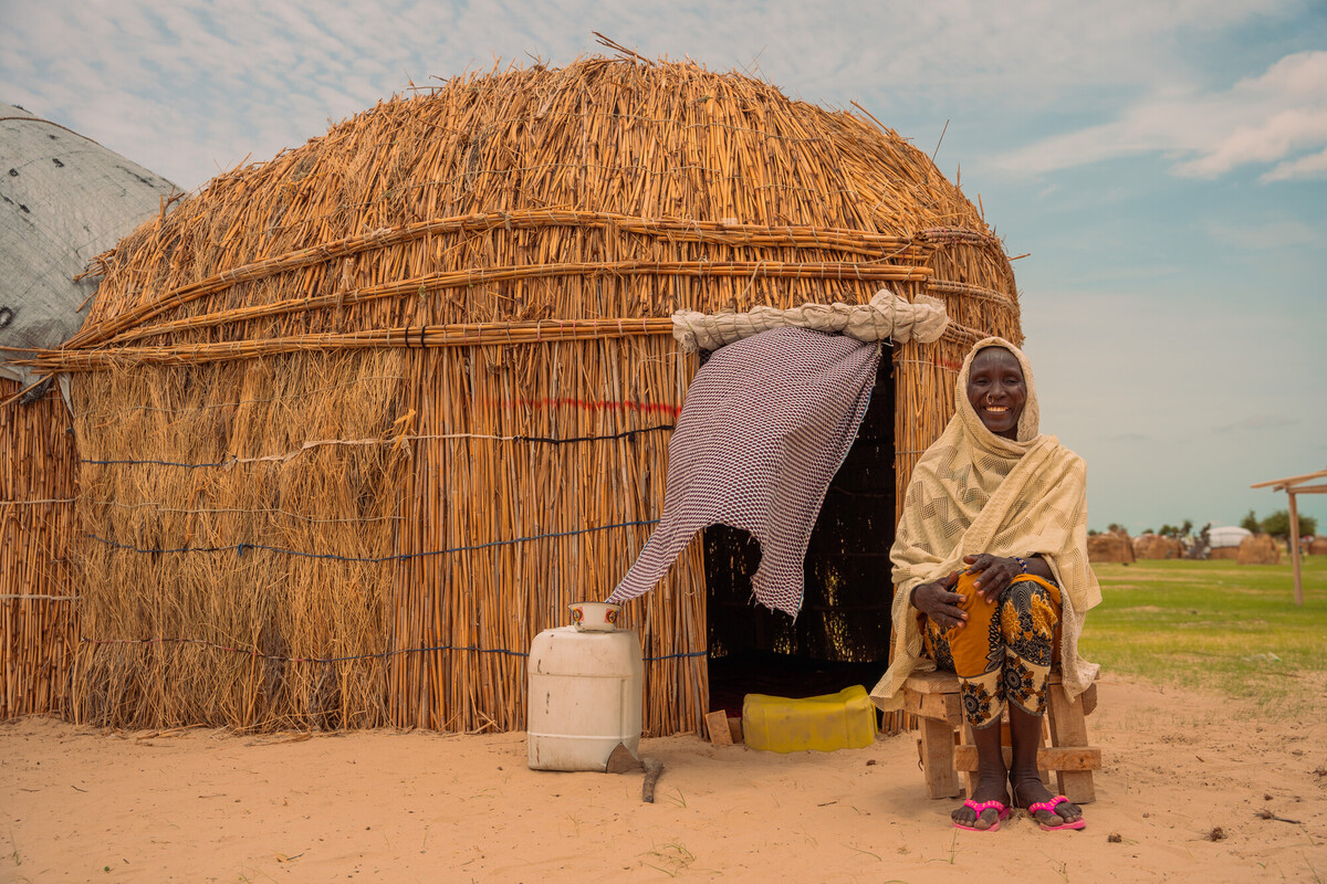Chad. Yaka, rifugiata climatica, di fronte alla propria capanna, di fronte al lago Chad. Yaka ha perso sei figli a causa delle frequenti alluvioni e degli scontri avvenuti dopo di essi. Foto. Adam Kraglaye/Oxfam