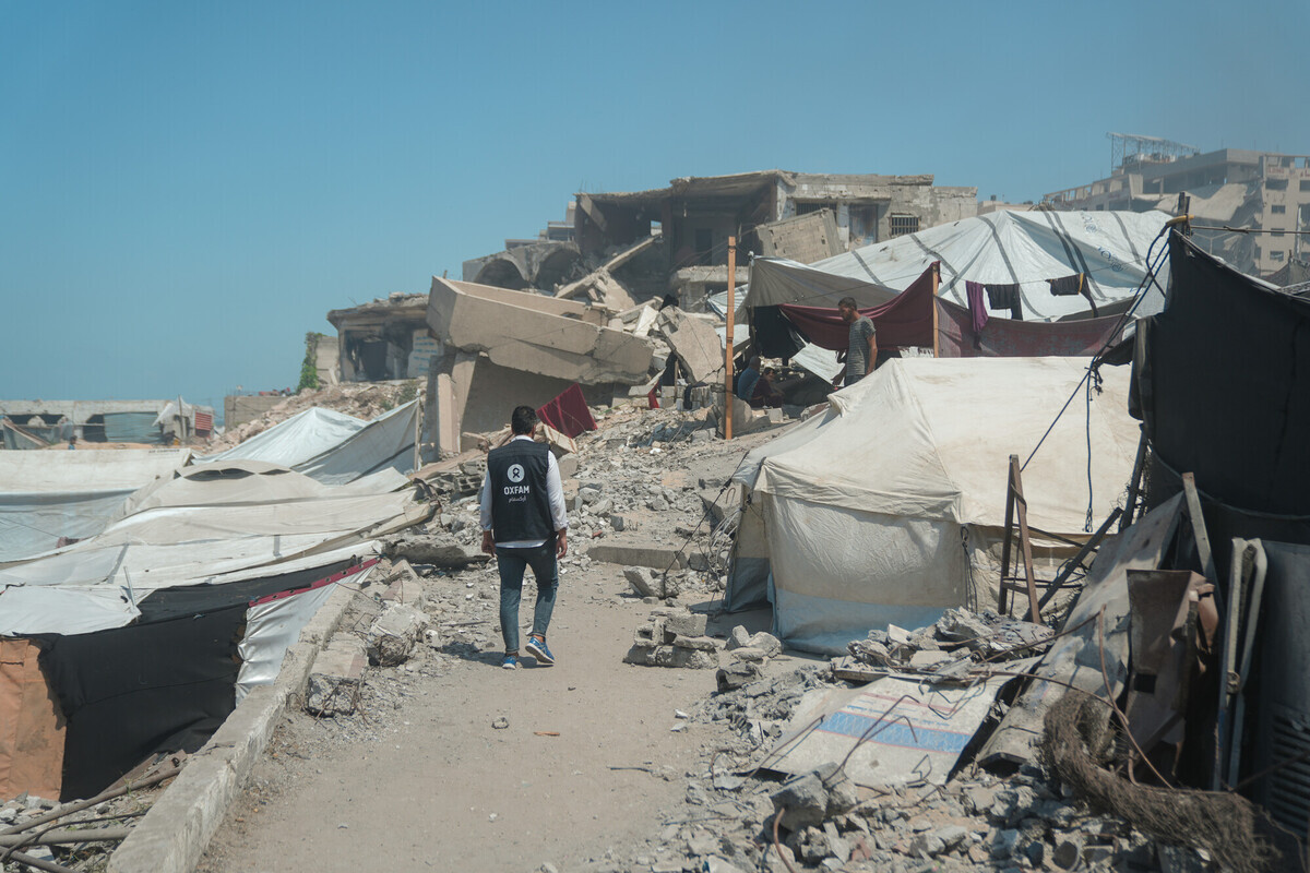 Un operatore di Oxfam cammina tra le tende e le macerie a Gaza City. Credit: Alef Multimedia/Oxfam 