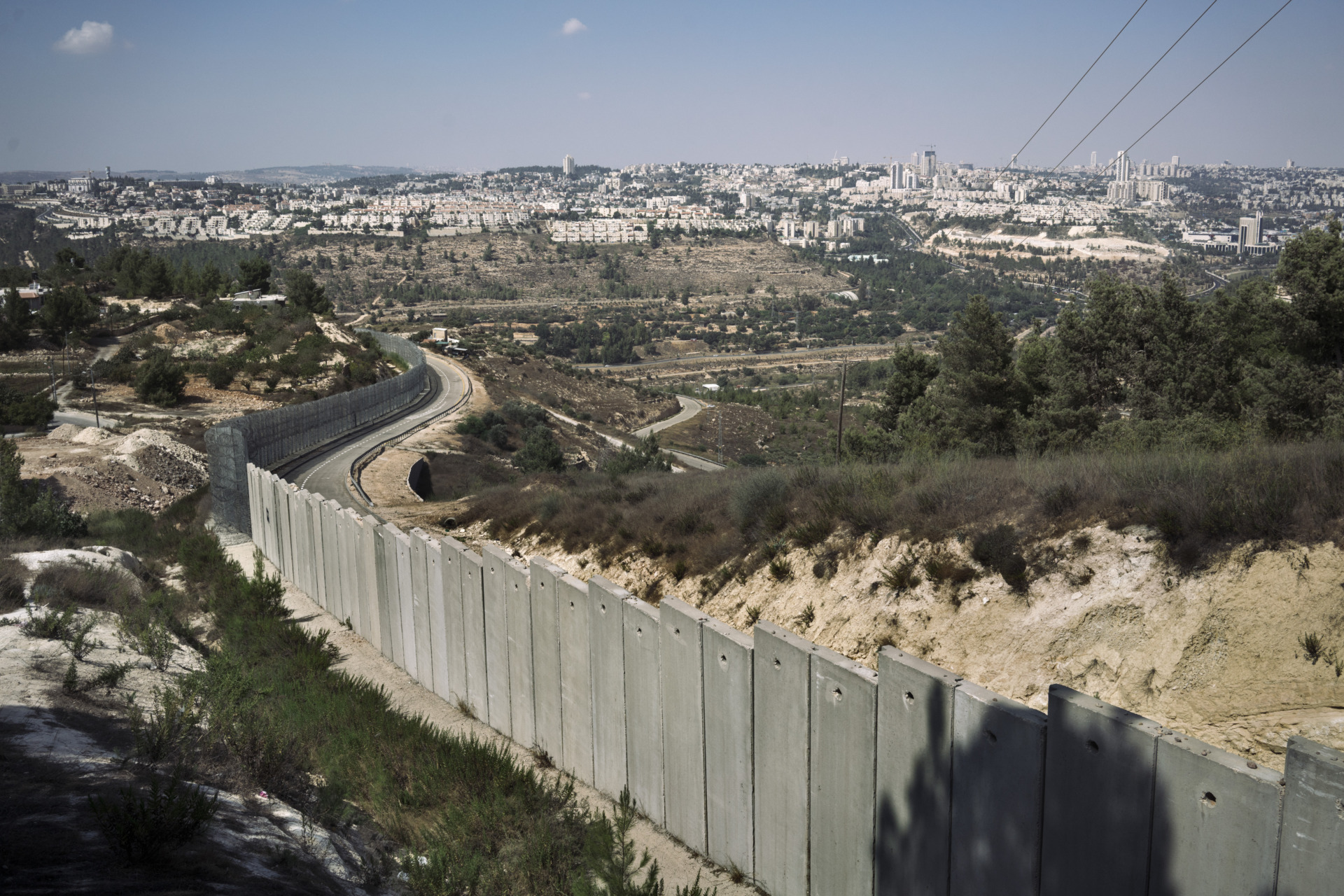 Una sezione del muro in prossimità della città di Betlemme. Dall’altra parte è visibile un gruppo di insediamenti in costruzione.