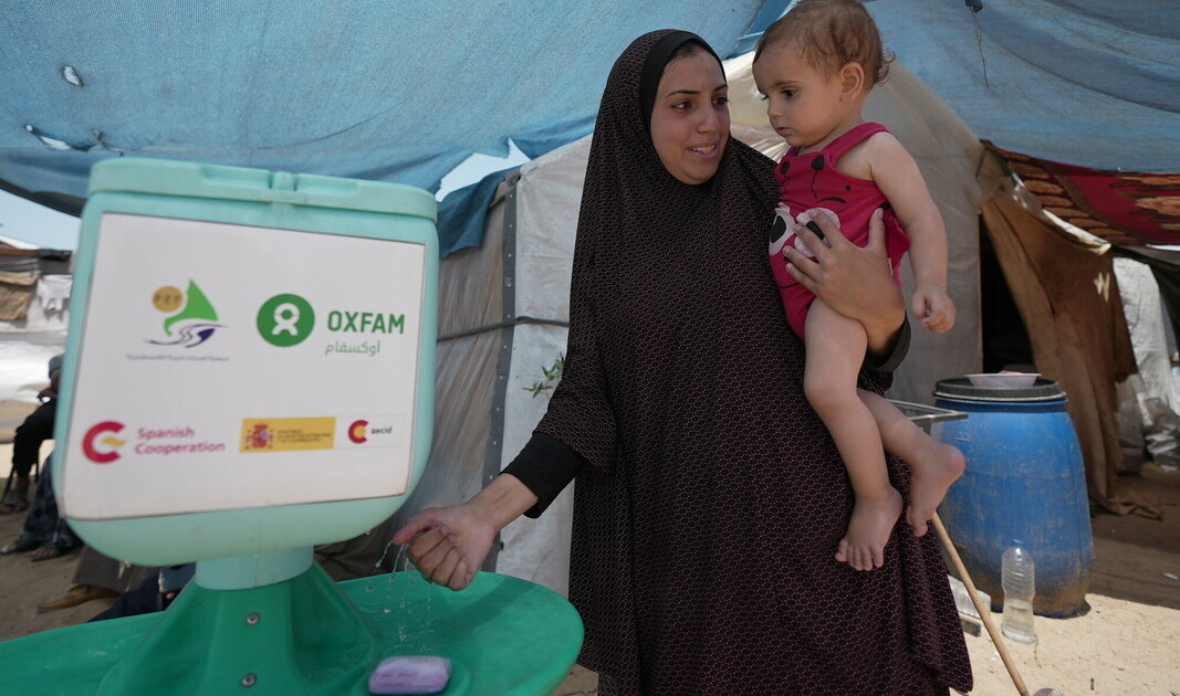 Duaa Abu Sabha utilizza la postazione per il lavaggio delle mani distribuita da Oxfam in risposta alle esigenze delle persone nella zona di Al-Mawasi, nel governatorato di Khan Yunis.