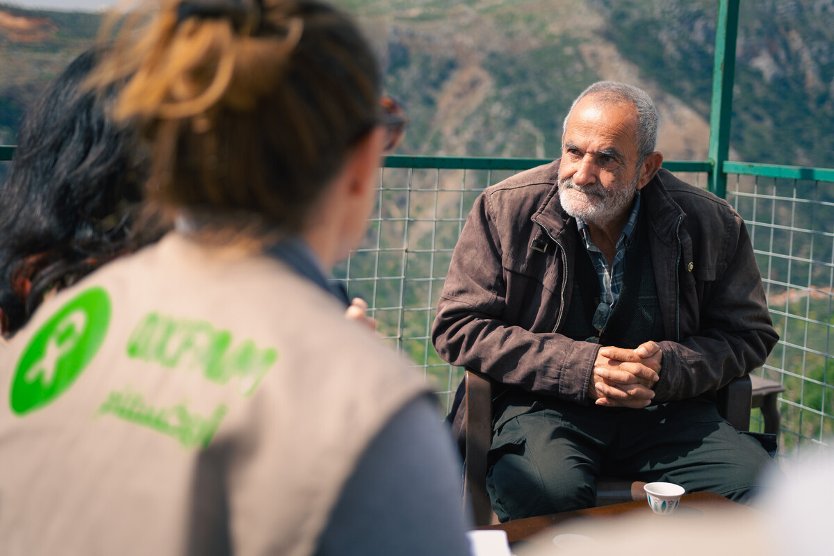 Il personale di Oxfam parla con Awad, residente di Deir Mimas, della guerra e della carenza d'acqua. Credit: Christian Harb/Oxfam
