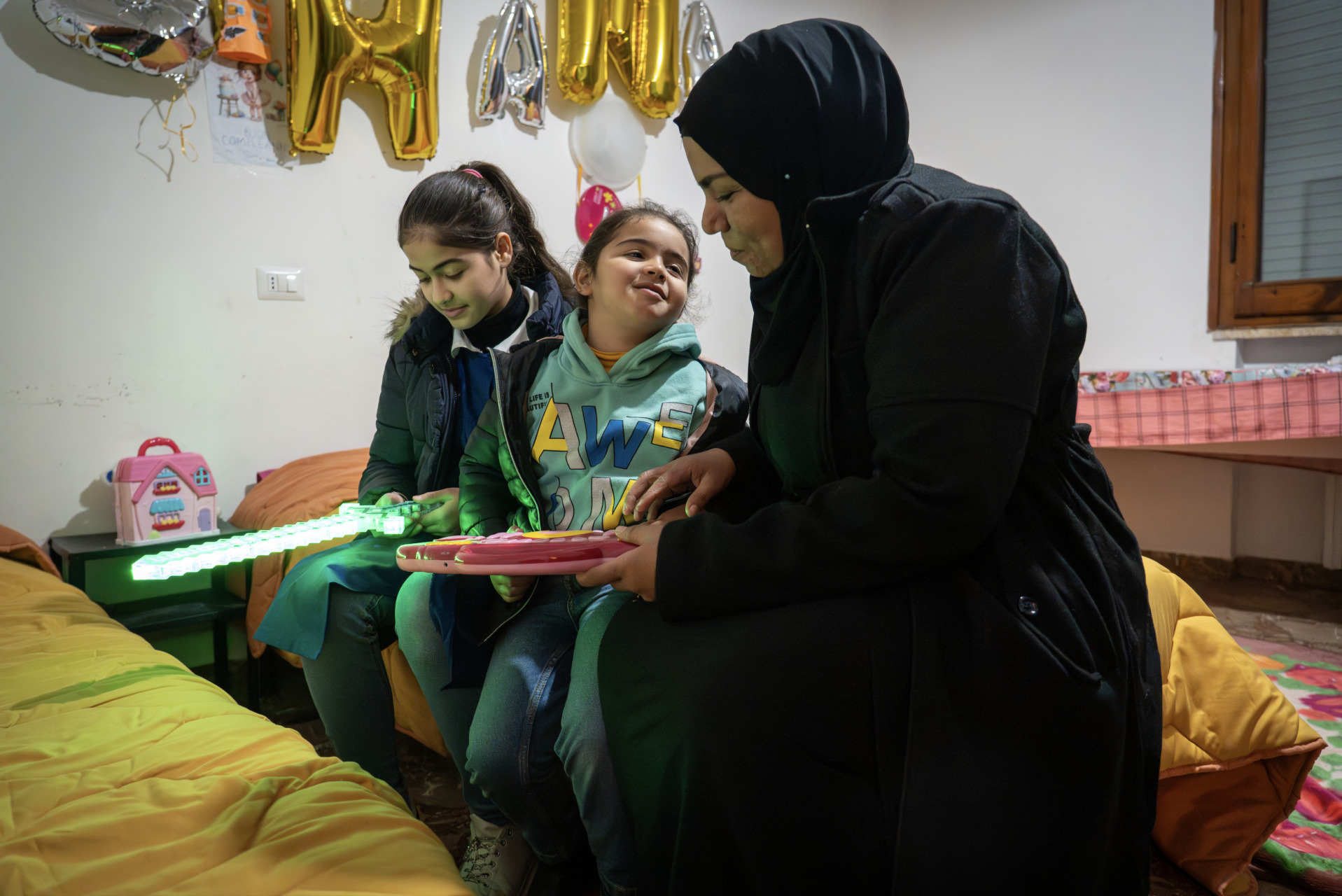 Taha Suha Samih Mahamud con la figlia maggiore (Rahaf) e la figlia più piccola (Hana) nella loro casa a Empoli, Firenze. Foto: Annalisa Ausilio/Oxfam