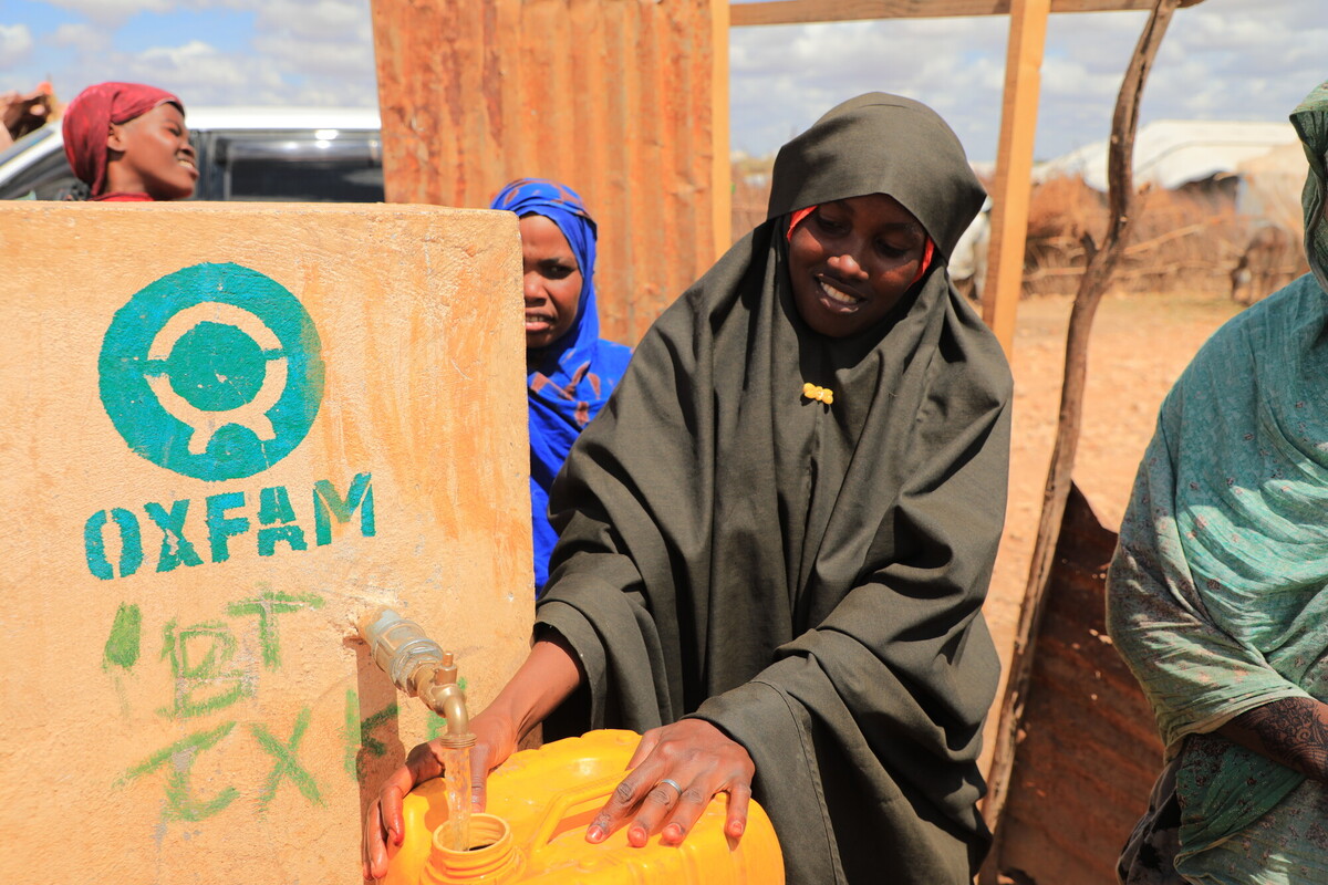 Una donna preleva acqua da un serbatoio che Oxfam ha costruito a Beledweyne, in Somalia, alleggerendo notevolmente il carico di lavoro delle donne e delle ragazze che in precedenza dovevano percorrere lunghe distanze per procurarsi l'acqua. Credit: Mohamoud Ali/Oxfam 