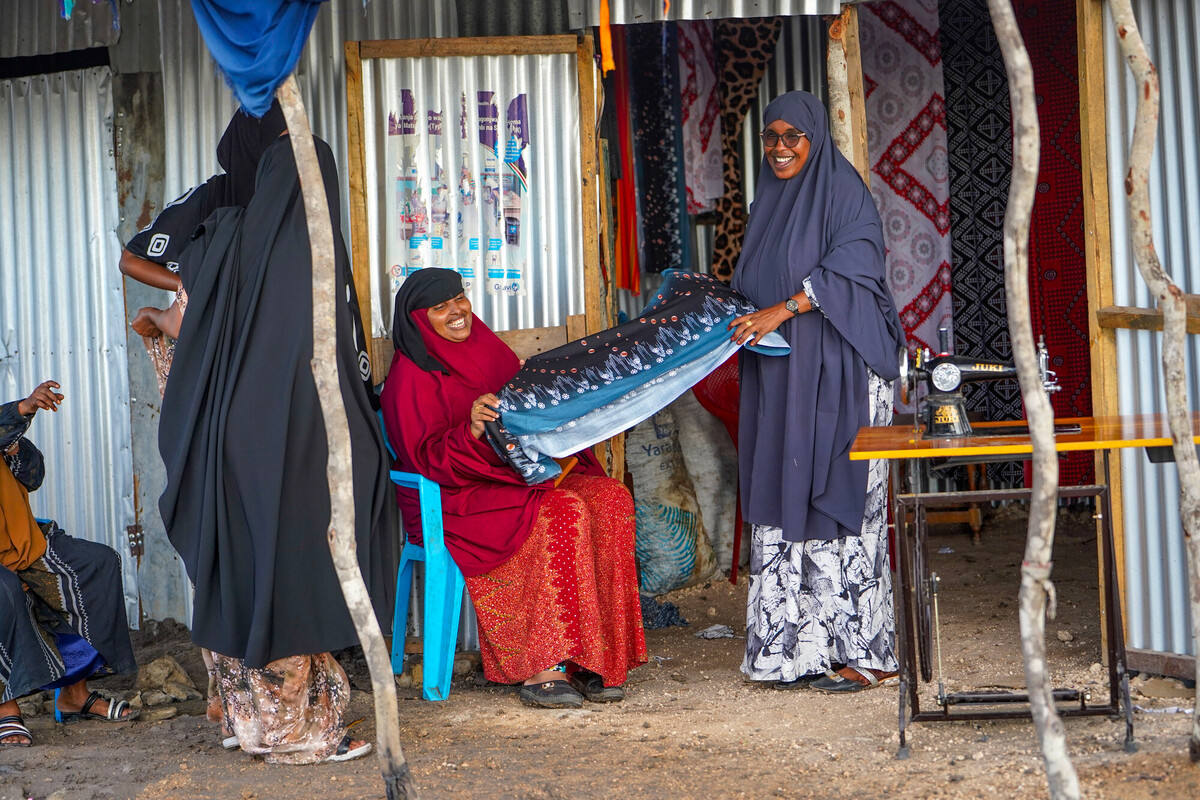 Madina Yunis Mahat, coordinatrice per le questioni di genere e la salute presso la Pastoralists Girls Initiative (PGI), insieme ad alcune donne dell'Alliance One Group, esamina gli abiti realizzati nel laboratorio del gruppo. Credit: James Ekwam/Oxfam