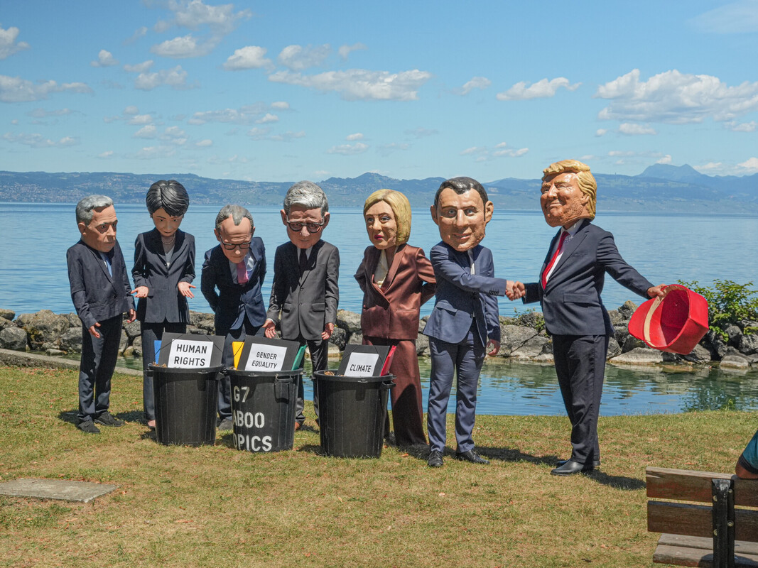 Sulle pittoresche rive del Lago Léman, a Evian, i nostri attivisti impersonano i leader del G7, disposti intorno a un bidone della spazzatura traboccante di enormi fascicoli scartati. Dietro alle strette di mano, le priorità scartate: clima, disuguaglianze, giustizia fiscale. Foto: Axel Duret/Oxfam