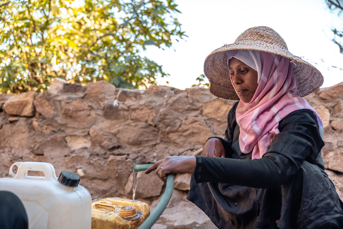 Dopo un viaggio lungo ed estenuante, Abeer raggiunge il pozzo e riempie il suo contenitore d’acqua. Credit: Ahmed Albasha / Oxfam