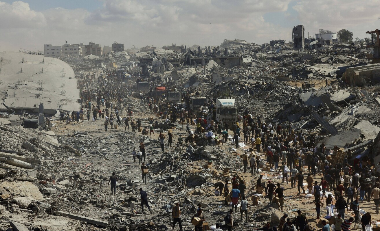 Alcune persone camminano lungo una strada gravemente danneggiata a Khan Younis, nel sud della Striscia di Gaza. Credit: Rashad/MEI/SIPA/Shutterstock