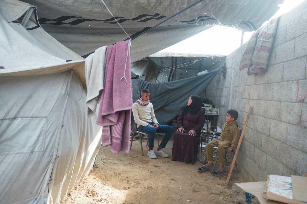 Rawya, beneficiaria del programma di assistenza in denaro di Oxfam a Gaza, è seduta con i suoi figli nella tenda in cui vivono in un accampamento improvvisato a Gaza. Credit: Mosab Al-Borno/ Alef Multimedia/ Oxfam