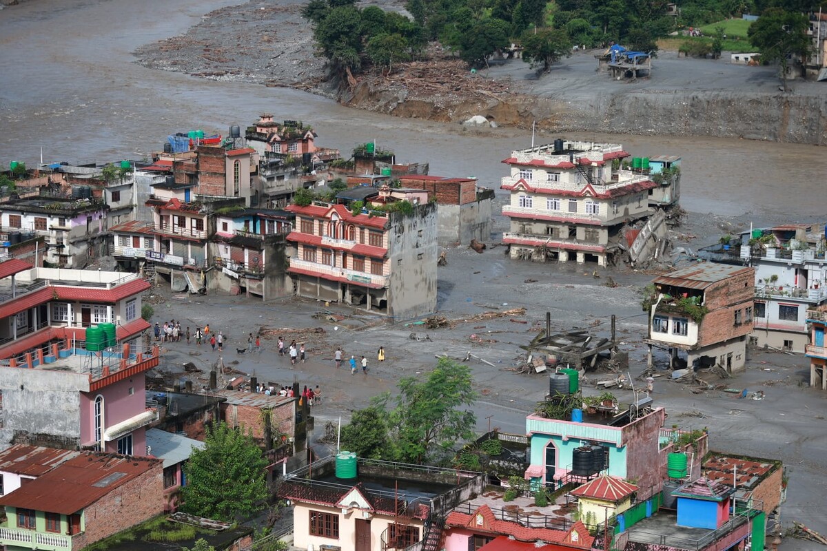 La scena mattutina a Devighat, nel distretto di Nuwakot, mostra le conseguenze di una grave alluvione. Gli abitanti stanno cercando disperatamente di recuperare gli oggetti ancora utilizzabili dalle loro case allagate. Credit: Nepal Photo Library