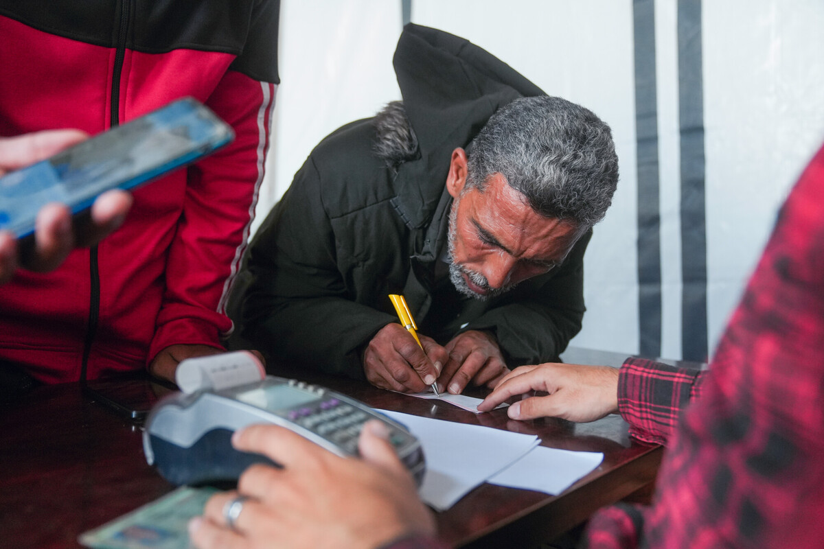 Bilal si reca in un negozio di alimentari locale a Gaza per fare la spesa dopo aver ricevuto un sussidio in denaro da Oxfam. Credit: Mosab Al-Borno/ Alef Multimedia/ Oxfam